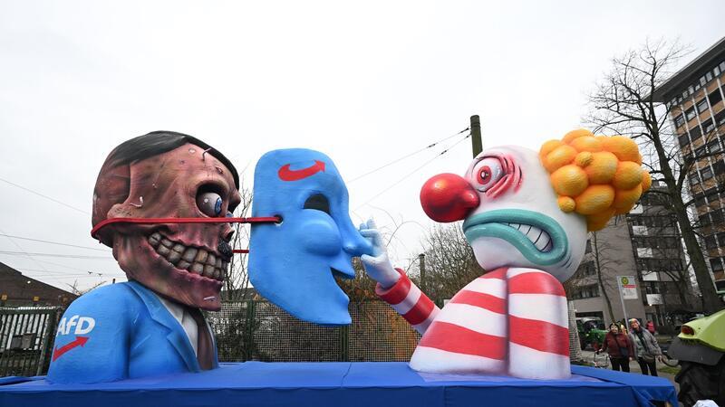 Rosenmontagszüge in Köln, Düsseldorf und Mainz unterwegs Versteckt hinter der blauen Maske: In Düsseldorf gibt es auch einen Wagen zur AfD.