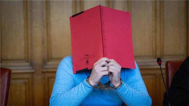 Versteckt hinter einer roten Mappe: Einem 35 Jahre alten ehemaligen Tanztrainer wird am Landgericht Bremen schwerer sexueller Missbrauch von Kindern und Jugendlichen vorgeworfen. 