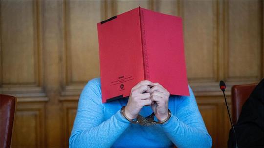 Versteckt hinter einer roten Mappe: Einem 35 Jahre alten ehemaligen Tanztrainer wird am Landgericht Bremen schwerer sexueller Missbrauch von Kindern und Jugendlichen vorgeworfen. 