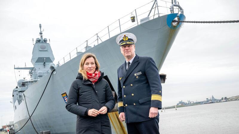Verteidigungsstaatssekretärin Siemtje Möller (l) steht mit Flottillenadmiral Axel Schulz vor der Fregatte „Hessen“.