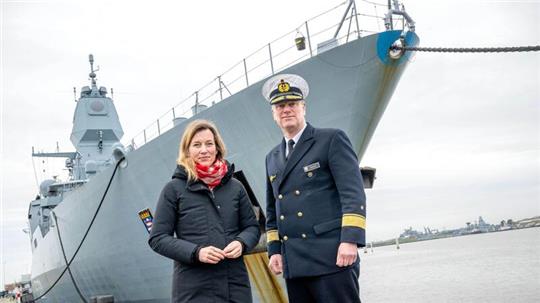Verteidigungsstaatssekretärin Siemtje Möller (l) steht mit Flottillenadmiral Axel Schulz vor der Fregatte „Hessen“.