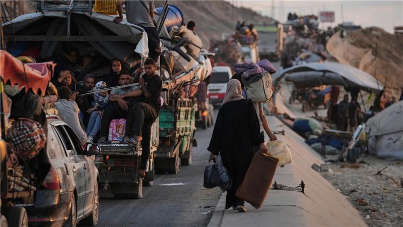Vertriebene Palästinenser, die aus dem nördlichen Gazastreifen fliehen, tragen ihre Habseligkeiten entlang der Küstenstraße in Richtung des südlichen Gazastreifens.