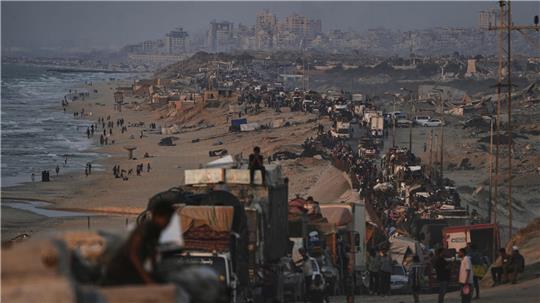 Vertriebene Palästinenser fliehen aus Gaza und tragen ihre Habseligkeiten entlang der Küstenstraße in Richtung des südlichen Gazastreifens. 
