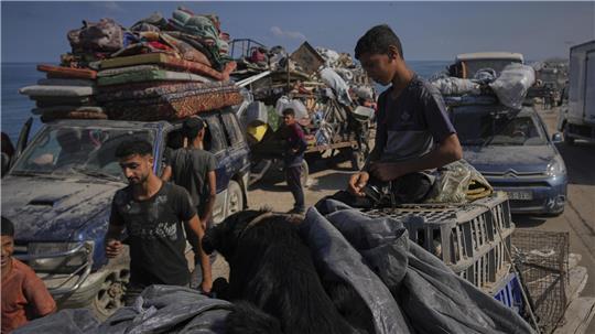 Vertriebene Palästinenser tragen ihre Habseligkeiten, während sie aus dem nördlichen Gazastreifen entlang der Küstenstraße in Richtung Süden fliehen, nachdem Israel eine erweiterte Operation in Gaza-Stadt angekündigt hat. 
