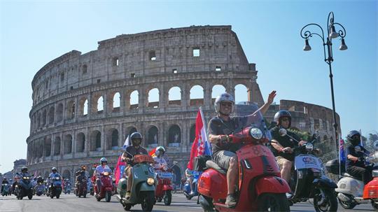 Vespa-Fans fahren am Kolosseum vorbei.