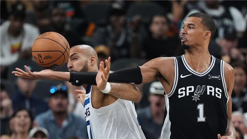 Victor Wembanyama (r) greift über Rudy Gobert (l) nach einem Rebound.