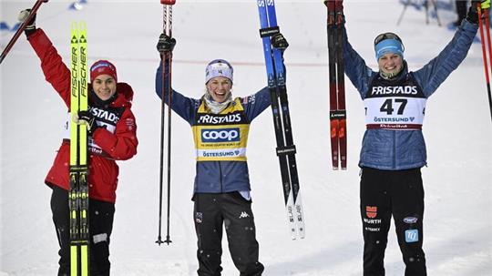 Victoria Carl (r) stand hinter Siegerin Jessie Diggins (M.) und Heidi Weng auf dem Podest.