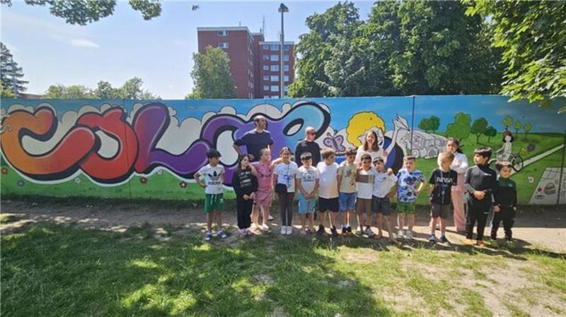 Viel Spaß hatten die Kinder und Jugendliche beim Graffiti-Projekt des Jugendmigrationsdienstes im Quartier: Am Spielplatz an der Warthestraße haben sie die Rückwände von 17 Garagen besprüht und so ein großflächiges Kunstwerk gestaltet.