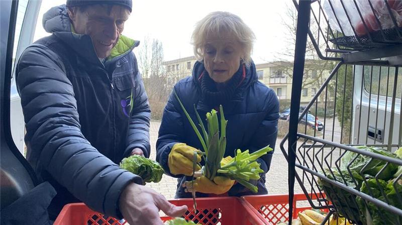 Marina Mächler und Olaf Ruser zupfen welke Blättern von Salat und Lauchzwiebeln