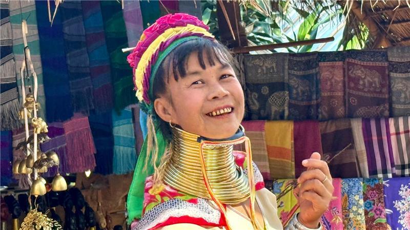 Bei den Langhalsfrauen von Chiang Rai: Kultur oder Kommerz? Viele Frauen schützen ihr Kinn mit Tüchern vor den schweren Ringen.