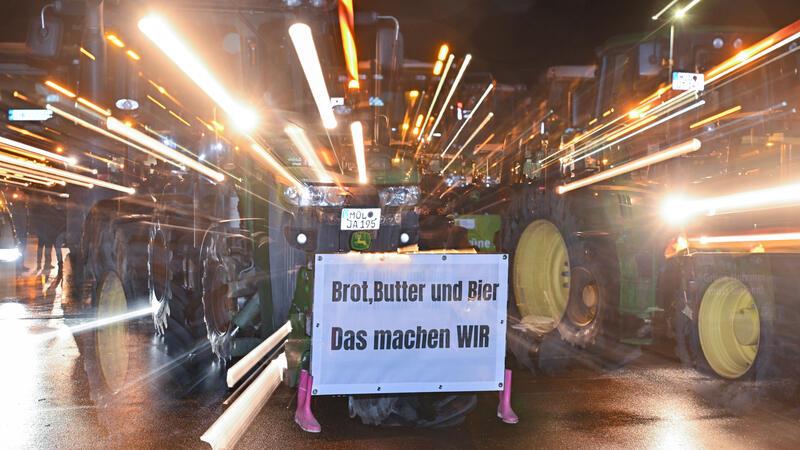 Landwirte protestieren: Aldi-Blockade im Stader Nachbarkreis ist beendet Viele Traktoren von Landwirten stehen am frühen Morgen auf einem Parkplatz, um sich für ihre Fahrt in Richtung Berlin zu sammeln (Zoomeffekt).