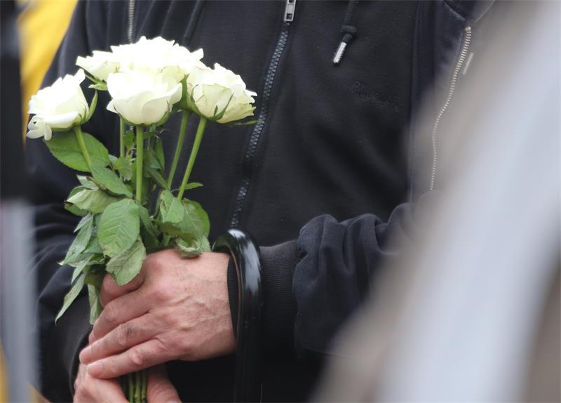 Viele halten Blumen in den Händen.