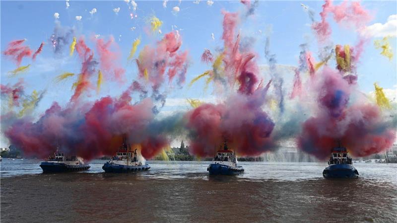 Vier Schiffe schießen beim Schlepperballett auf dem Hamburger Hafengeburtstag bunten Rauch in die Luft. Vom 9. bis zum 11. Mai lockte das Volksfest mit Veranstaltungen auf dem Wasser und an Land über eine Million Gäste zum Hamburger Hafen.