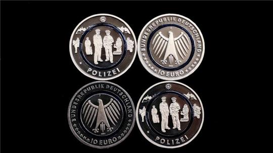 Vier neue 10-Euro-Gedenkmünzen „Polizei“ liegen auf einem Tablett in der Hamburgischen Münze.