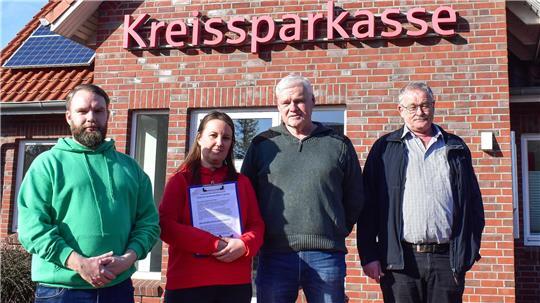 Andreas Neumann, Corinna Lange, Gerhard Dammann und Jörg Müller stehen vor der Sparkassen-Filiale in Deinste.