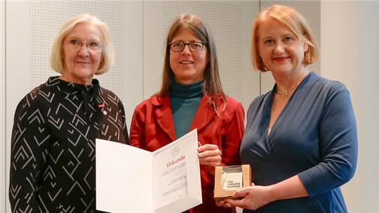 Vizepräsidentin Heidi Kluth (links) und Christina Völkers, Leiterin der Koordinierungsstelle zur Frauenförderung, nehmen die Auszeichnung von Bundesfamilienministerin Lisa Paus entgegen.
