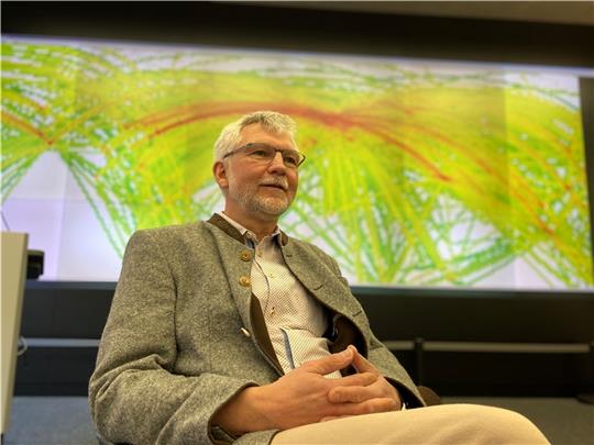 Volker Gollnick vor einer Karte: Sein Institut für Lufttransportsysteme an der TU Hamburg gehört weltweit zu den führenden auf dem Gebiet der Klimawirkungsforschung. Foto: Scholz