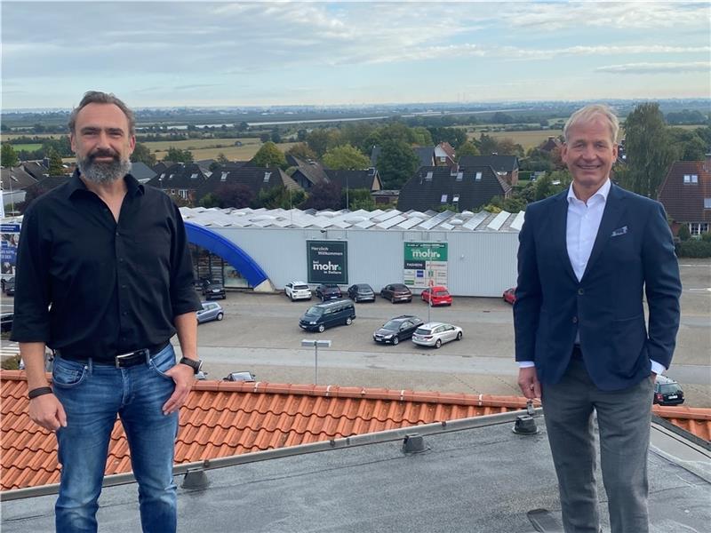 Volker Mohr (rechts) mit dem künftigen Heimtiermarkt-Betreiber Helge Löbus auf dem Dach des Modehauses in Dollern. Im Hintergrund ist das Gebäude zu sehen, in dem der neue Markt eröffnet wird. Foto: Stephan