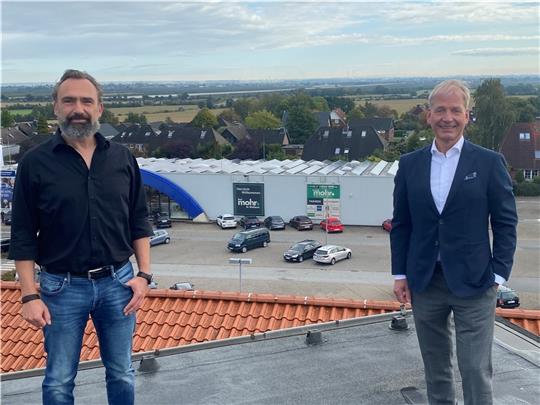 Volker Mohr (rechts) mit dem künftigen Heimtiermarkt-Betreiber Helge Löbus auf dem Dach des Modehauses in Dollern. Im Hintergrund ist das Gebäude zu sehen, in dem der neue Markt eröffnet wird. Foto: Stephan