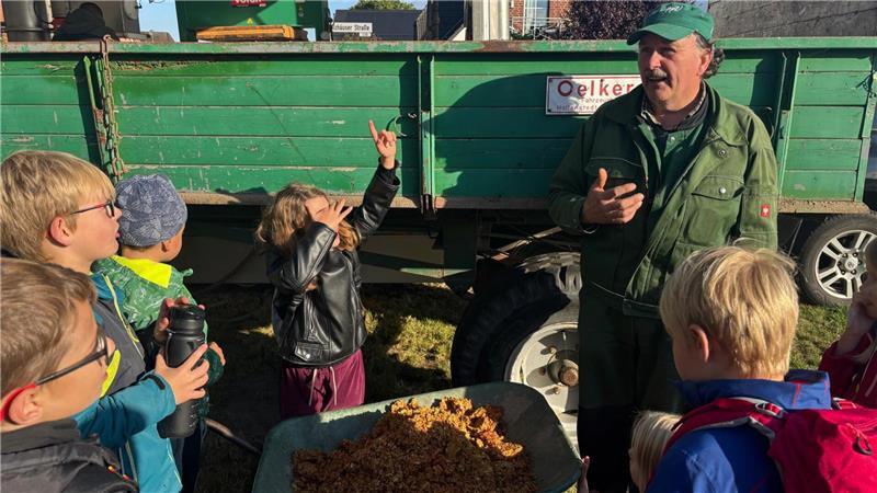 Ahlerstedter Kinder helfen: Wenn tonnenweise Äpfel zu Saft werden Volkhard Treisch erklärte den Kindern, was Apfeltrester ist.