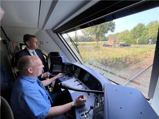 Volle Kraft voraus für den Personennahverkehr auf der Strecke Stade-Bremervörde ab 2026: Der Niedersächsische Verkehrsminister Olaf Lies (SPD) schaut EVB-Lokführer Christian Glauner im Wasserstoffzug über die Schulter. Foto: Vasel