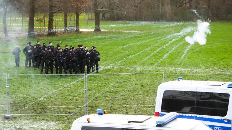 Von Aktivisten abgeschossene Pyrotechnik fliegt in Richtung von Polizisten.