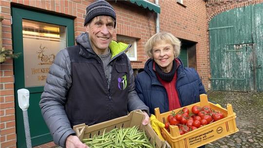 Olaf Ruser und Marina Mächler kommen mit zwei Kisten voll Bohnen und Tomaten aus dem Hofladen des Immenbecker Betriebs 