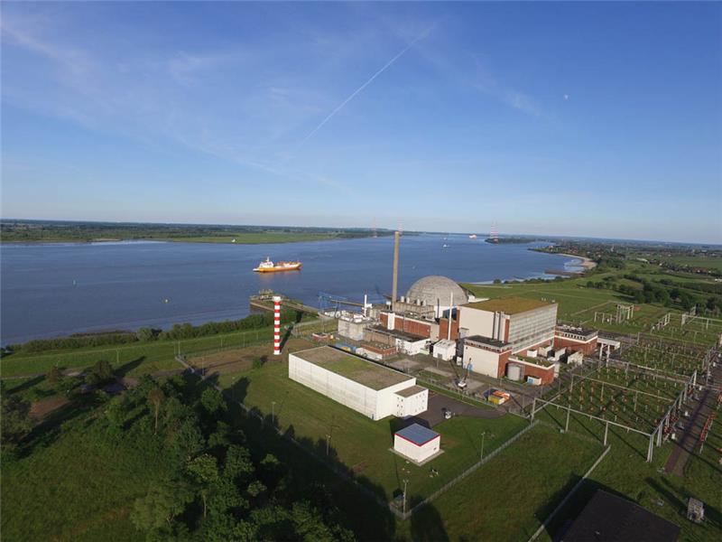 Von außen der bekannte Anblick: das Kernkraftwerk an der Elbe in Bassenfleth, neben dem rot-weiß geringelten Leuchtturm steht das Zwischenlager „Lara“. Foto: PreußenElektra