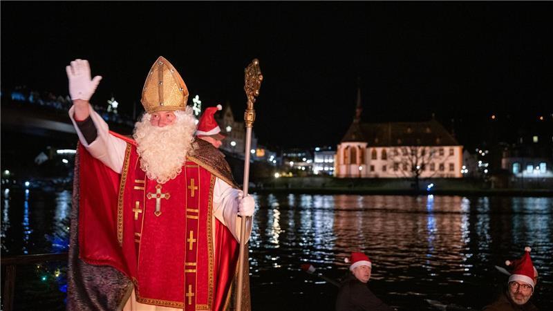 Von zahlreichen Fackelschwimmern begleitet ist der Nikolaus in Bernkastel-Kues in einem Ruderboot über die Mosel gekommen.