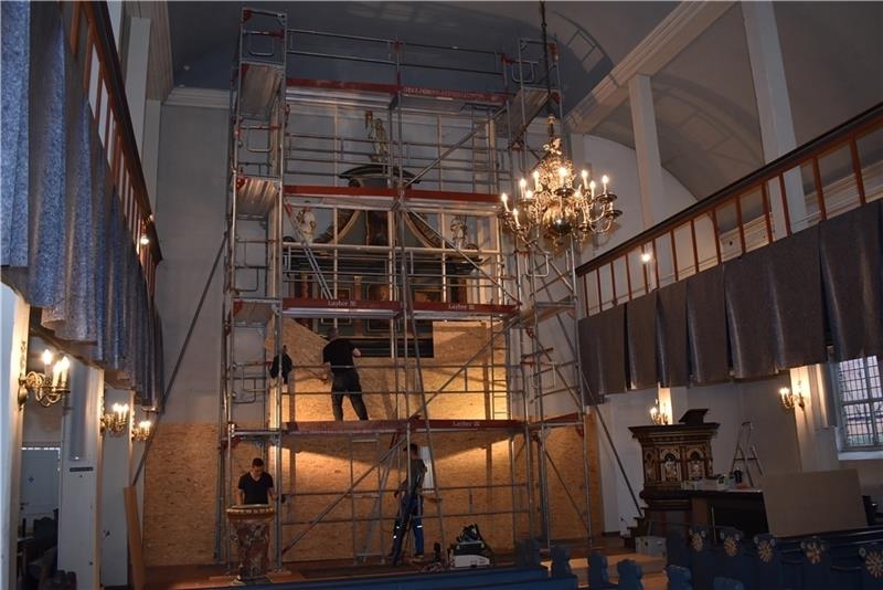 Vor Beginn der Renovierung: Die Schätze der Liebfrauenkirche in Horneburg werden von Tischlermeister Bertram Düring aus Sachsen staubdicht eingehaust – unter anderem den Altar von 1729. Foto: Vasel