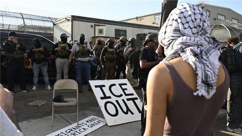 Vor Bundesbeamten der Einwanderungsbehörde ICE haben Demonstrierende ein großes Schild mit der Aufschrift „ICE out“ drapiert.