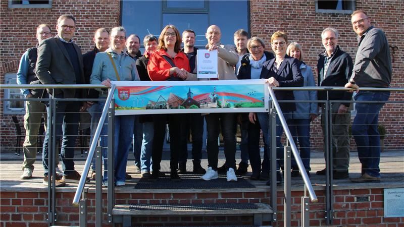 Vor dem Historischen Kornspeicher übergab Gemeindedirektor Ernst Hülsen den Aufnahmeantrag an Karin Beckmann (Mitte).