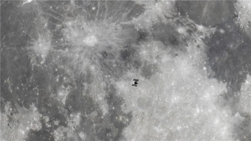 Vor dem Mond: Die Internationale Raumstation (ISS) schwebt im Weltall.