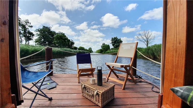 Vor dem überdachten Holzaufbau, der sich auch für Übernachtungen eignet, gibt es eine kleine Holzterrasse. Zwei Liegestühle sind inklusive. Den Picknickkorb muss jeder selbst mitbringen. Foto: Leuschner