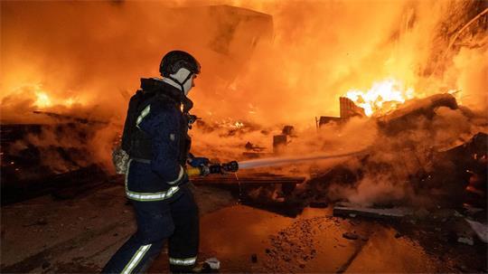 Vor den Flammen: Ein Feuerwehrmann löscht nach dem russischen Luftangriff einen Brand in einem Wohngebiet.
