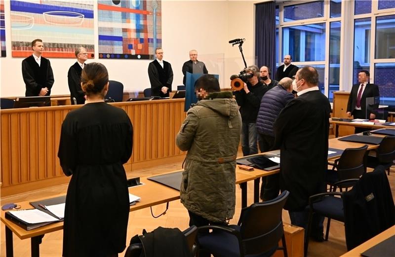 Vor der 2. Großen Strafkammer des Stader Landgerichts hat am Montagmorgen die Hauptverhandlung gegen den mutmaßlichen „Imbiss-Mörder“ von Stade (Mitte) unter dem Vorsitz von Richter Berend Appelkamp (hinten, Zweiter von links) begonnen. Vor