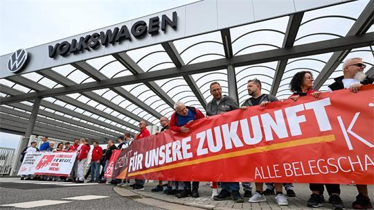 Vor der Betriebsversammlung von VW in Zwickau demonstrieren Beschäftigte am Werkstor.