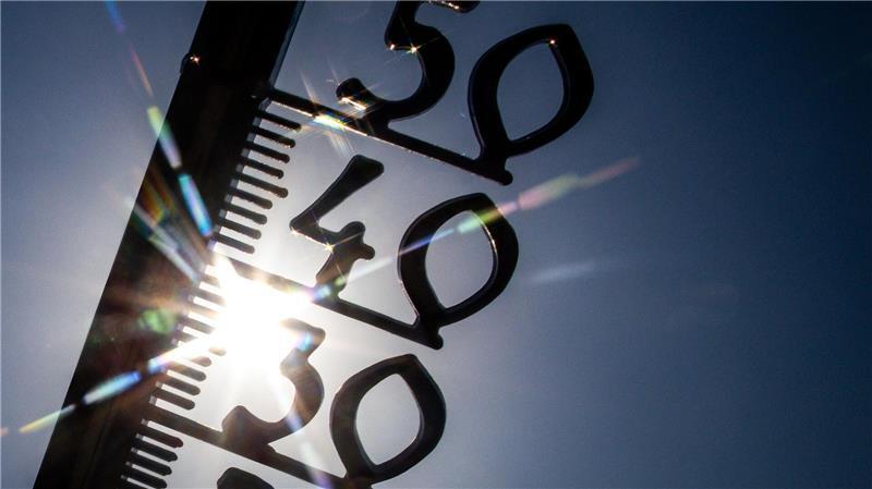 Erde am Limit – Klimakrise kostet Millionen von Leben Vor einem wolkenlosen blauen Himmel zeigt ein Außenthermometer in einem Garten bereits am Vormittag über 30 Grad Lufttemperatur an. (Illustration)