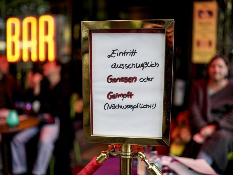 Vor einer Bar im Hamburger Stadtteil St. Georg steht ein Hinweisschild, welches auf den Einlass nach der 2G-Regel hinweist. Foto: Axel Heimken/dpa