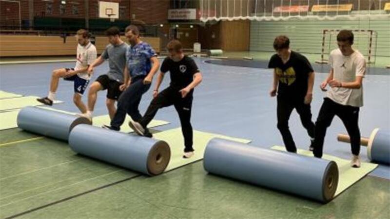 Vor jedem Heimspiel der Bundesliga-Mannschaft des Buxtehuder SV rollen Freiwillige den Handball-Boden aus und bauen ihn nach dem Spiel wieder ab.