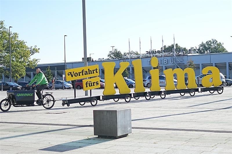 "Vorfahrt fürs Klima" lautet der Schriftzug auf dem Fahrradanhänger, mit dem ein Aktivist von Greenpeace vor den Sondierungsgesprächen protestiert. Foto: Michael Kappeler/dpa