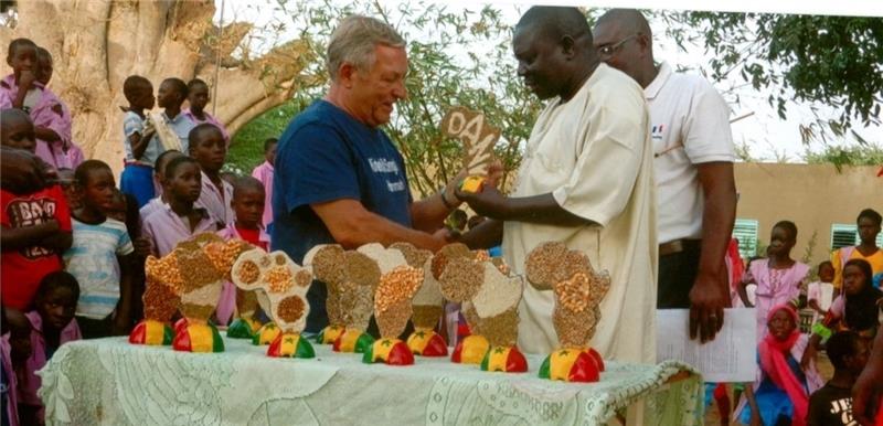 Vorsitzender Gerhard Dodenhoff nimmt Geschenke der Schule Samba Gueye entgegen. Dort hat die Kinderhilfe einen Computerraum geschaffen.