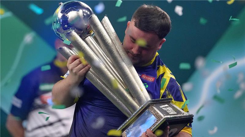 WM, Finale, Littler (England) - van Veen (Niederlande). Der Engländer Luke Littler hebt die Trophäe nach seinem Sieg. Im deutschen Fernsehen ist die Darts-WM im Free-TV noch einmal bei Sport1 zu sehen, dann wechselt der Sender.