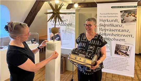 Während Dr. Kai Janofsky das Schild für die Giebelzierde aus dem 19. Jahrhundert montiert, hat Kuratorin Barbara Wetegrove einen Dauerwellenapparat von 1940 für die Ausstellung aus dem Magazin geholt.