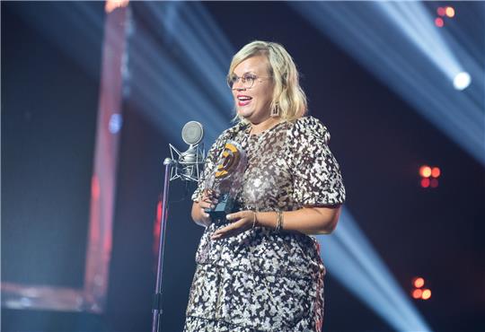 Während der Verleihung des Deutschen Radiopreises 2022 steht Martina Schönherr vom Sender N-JOY vom NDR auf der Bühne mit dem Preis in der Kategorie "Beste Moderatorin". Foto: Daniel Bockwoldt/dpa