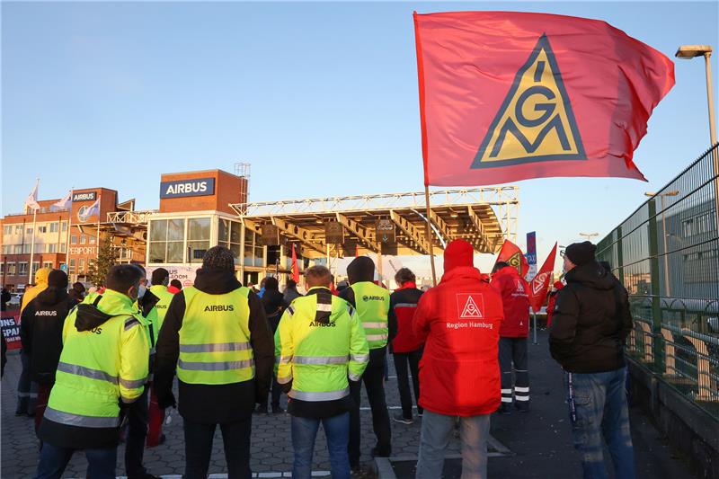 Während einer Aktion zur Aufsichtsratssitzung von Airbus stehen Mitglieder der IG Metall vor einem Werkstor von Airbus in Hamburg-Finkenwerder. Foto: Bodo Marks/dpa