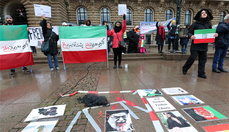 Während einer Demonstration gegen das politische Regime im Iran liegen Plakate und eine Perücke mit roter Farbe auf dem Rathausplatz. Foto: Bodo Marks/dpa