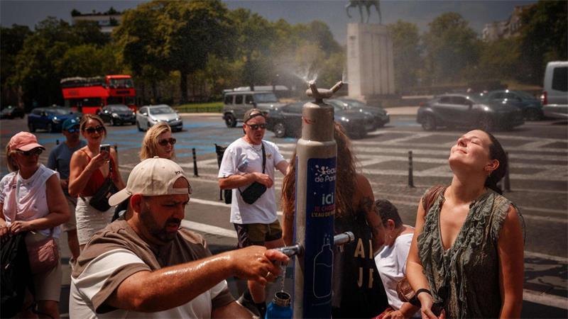 Während einer Hitzewelle in Paris suchen Menschen an einem Nebelbrunnen auf der Place du Trocadéro Abkühlung.