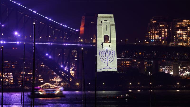 Während einer Schweigeminute wurde ein Chanukkaleuchter auf einen Pfeiler der Sydney Harbour Bridge projiziert.