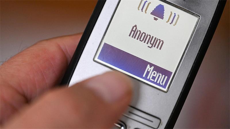 Während seine Frau die Betrüger am Festnetz in der Leitung hält, wählt Heinz Rademacher mit seinem Handy den Polizeinotruf 110. (Symbolbild)
